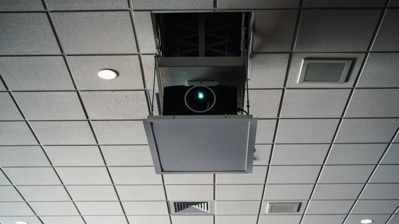 A large-venue projector lowered from a ceiling lift in a Jackson State University instruction space.