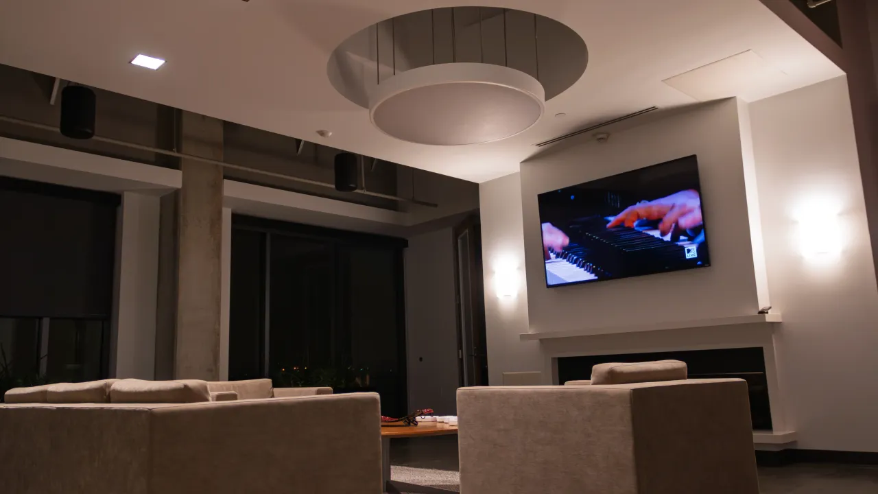 A communal fireplace lounge at SESAC with lounge seating and a wall-mounted display.