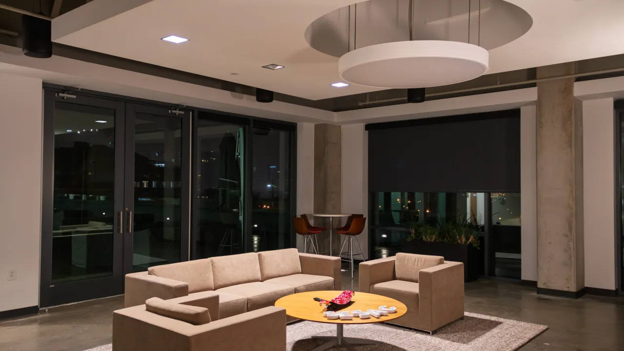 Another view of the communal lounge area with seating and perimeter pendant speakers.