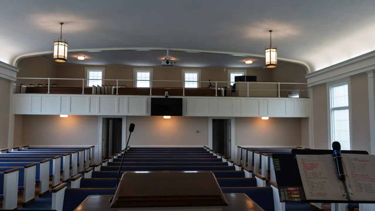 The sanctuary platform with a lectern, microphone, and a floor monitor speaker.