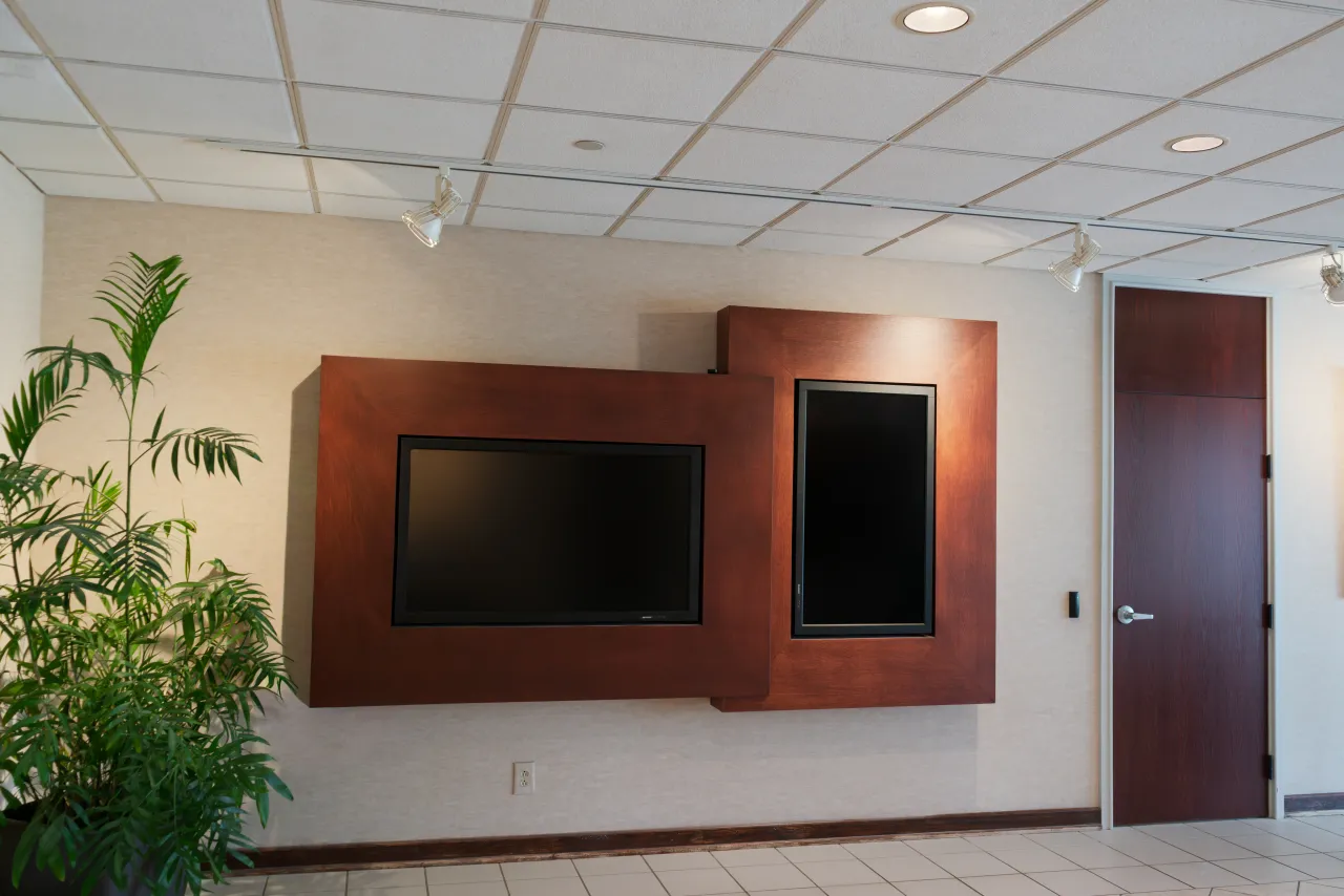 A public space at Tennessee Farm Bureau with two wall-mounted displays set in wood paneling.