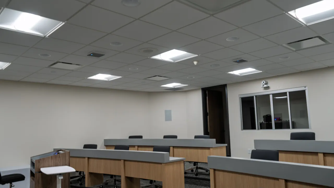 Another view of the training room showing tiered seating and a camera beside the control-room window.